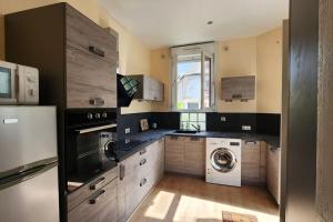 a kitchen with a washer and dryer in it at Grand gîte 150 m2 - 4 chambres - Salle de jeux avec billard et fléchettes in Péronne