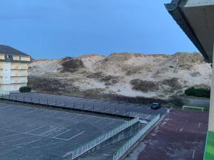 a parking lot with a mountain in the background at Le courant d’air in Fort-Mahon-Plage