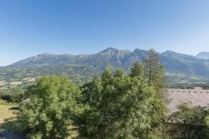 a group of trees with mountains in the background at Les Serinthes - Pour 4 station accessible à pied in Saint-Léger-les-Mélèzes