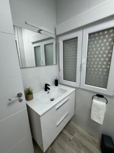 a white bathroom with a sink and a mirror at Linerlife in Málaga