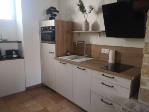 a small kitchen with a sink and a stove at Le Victor Noir in Chéroy