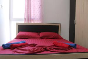 a bed with red and blue pillows on it at Holiday Gateway in Shëngjin