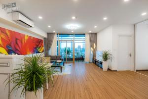 a living room with plants and a painting on the wall at Son&Henry Sailing Tower in Ho Chi Minh City
