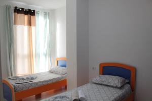 a bedroom with two beds and a window at Holiday Gateway in Shëngjin +42 photos