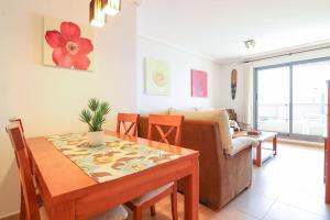 a living room with a table and a couch at Apartamento con piscina - Plazamayor 251 in Calpe