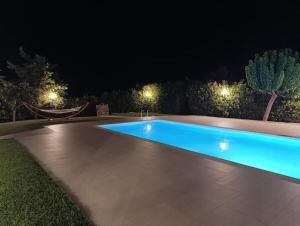 a swimming pool in a yard at night at Country house for4 in Markopoulo