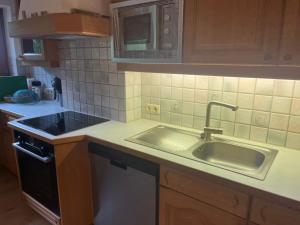 una cucina con un lavello e un piano di lavoro di Apartment Weitblick - Cosy 65m2 appartment with balcony a Finkenberg