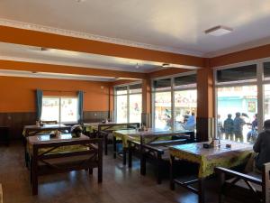MuktināthHotel Siddhartha & Khanglo Thakali Bhancha Ghar的餐厅内带桌子和人的餐厅
