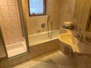 e bagno con doccia, lavandino e vasca. di Apartment Weitblick - Cosy 65m2 appartment with balcony a Finkenberg
