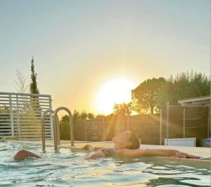 a young woman in a swimming pool with the sun setting at 87029house in Scalea +120 photos