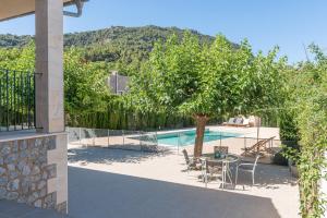 a pool with a table and chairs and a tree at Villa Son Vent Valldemossa in Valldemossa