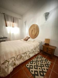 a bedroom with a bed with a basket on the wall at Casa Rural las Tres Rosas in Gaucín