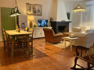 a living room with a table and a living room with a couch at Casa Rural las Tres Rosas in Gaucín