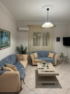 a living room with two couches and a table at Katies cozy corner in Chios