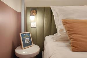 a hotel room with a bed and a sign on a toilet at Aparthotel AMMI Vieux Nice in Nice