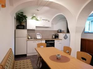 a kitchen with white cabinets and a wooden table at Ferienhotel Zwotatal in Klingenthal