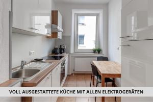 a kitchen with a sink and a wooden table at NEU Easy Sleep - FeWo mit 3 Zimmern bis 6 Personen, 5 Einzelbetten oder 2 Doppelbetten und 1 Schlafcouch, Küche, Tageslichtbad - Monteure willkommen in Bayreuth