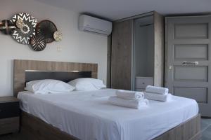 a bedroom with a bed with two towels on it at Antigoni Villas in Gavrio