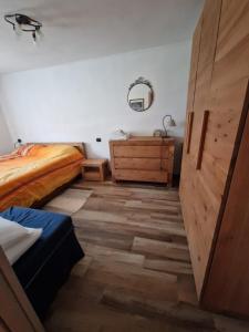 a bedroom with a bed and a dresser and a mirror at Appartamento sul Lago di Maen in Valtournenche