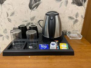 a coffee maker on a tray on a table at Hotel Leaf 9 Boutique, Near Golf Course Road and Galleria Market in Gurgaon
