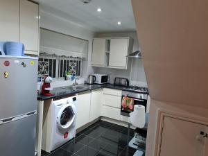 a kitchen with a washing machine and a washer at 4Br-2Ensuite-10minCentralLondon-Sleeps11-Parking in London +23 photos