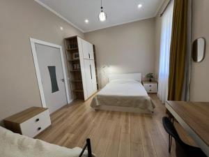 a bedroom with two beds and a wooden floor at Mziuri Guest House in Gonio