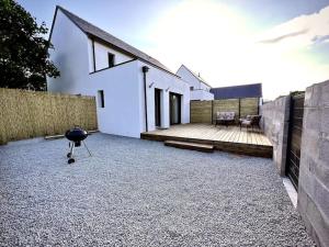 Saint-AvéにあるTy Ne Hue, Charmant Studio avec extérieur clos et Parkingのグリルとパティオのある白い家