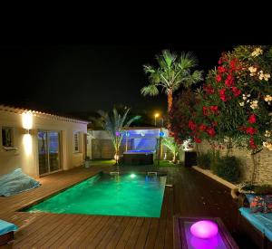 a swimming pool in a backyard at night at La maison du Bonheur 34 in Florensac