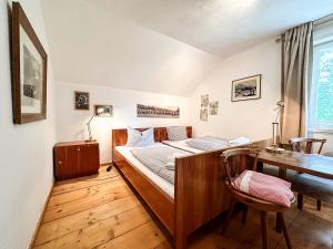 Un dormitorio con una cama, un escritorio y una mesa. en Zur Schneidemühle, en Oberstaufen