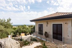 Casa con puertas negras y balcón en Casale Antiche Mura Siracusa, en Siracusa