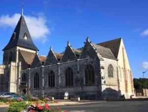 an old stone church with a steeple on a sunny at le Vermeil in Saint-Georges-sur-Eure