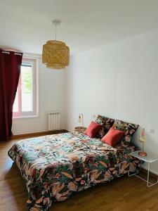 Un dormitorio con una cama con una colcha colorida. en le Vermeil, en Saint-Georges-sur-Eure