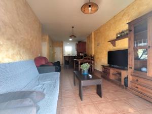 a living room with a couch and a tv at Apartamento OsMa in Bolnuevo