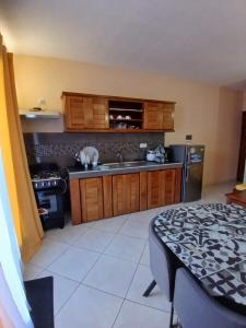 a kitchen with a table and a sink and a stove at Residence Adeline in Toamasina