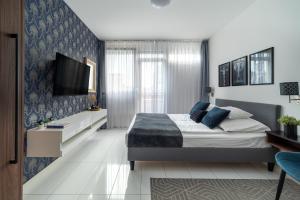 a bedroom with a bed and a tv on a wall at Geri Mini Home in Zalaegerszeg