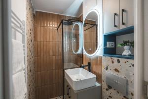 a bathroom with a sink and a mirror at Apartament Iulia si Alex in Curtea de Argeş