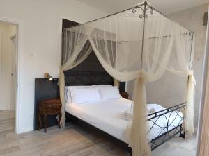 a bedroom with a canopy bed with white sheets and pillows at Luxury Apartments Riva Vena in Chioggia
