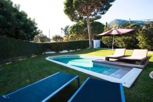 a backyard with a swimming pool and an umbrella at casa tranquila para relax in Cabrera de Mar