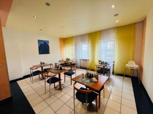 a restaurant with tables and chairs in a room at Hotel Niederräder Hof in Frankfurt