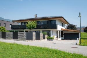 una casa bianca con una recinzione nera di Ferienwohnung Gartner a Uderns