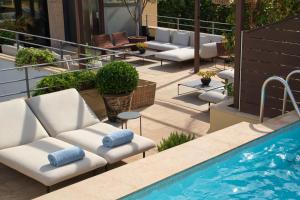 a patio with lounge chairs and a swimming pool at Hotel Can Alomar in Palma de Mallorca