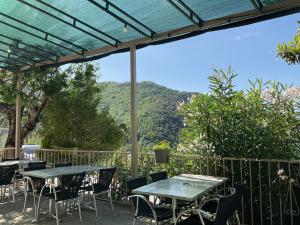 a patio with tables and chairs with mountains in the background at Hotel U Liccedu in Bustanico