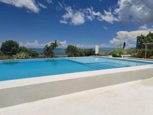 a large swimming pool with a view of the ocean at Nashu Three bedroom Townhouse in Dambani