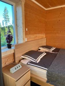 a bedroom with a bed in a wooden cabin at Luxury off grid house in Viksjöfors