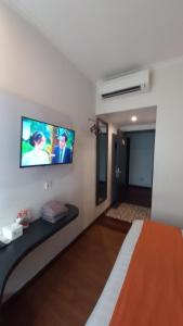 Kalibanteng-lorにあるFront One Boutique Tugu Muda Semarangの壁に薄型テレビが取り付けられた部屋
