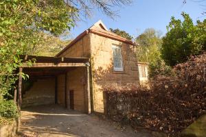 a brick building with a garage with a window at Berg Cottage in Clarens