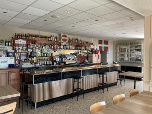 a bar in a restaurant with tables and chairs at Hotel U Liccedu in Bustanico