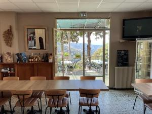 a dining room with a large wooden table and chairs at Hotel U Liccedu in Bustanico