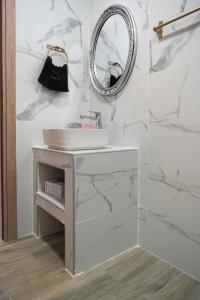 a bathroom with a sink and a mirror at Olympio Apartments in Xylokastron