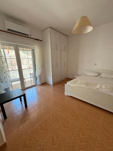 a bedroom with a bed and a table and a desk at Vila Isufi in Sarandë